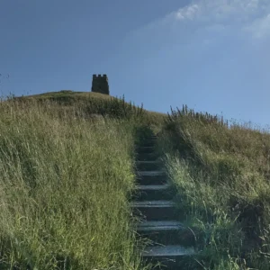 Stone steps leading up Glastonbury Tor under a bright sky, symbolizing a path of reflection